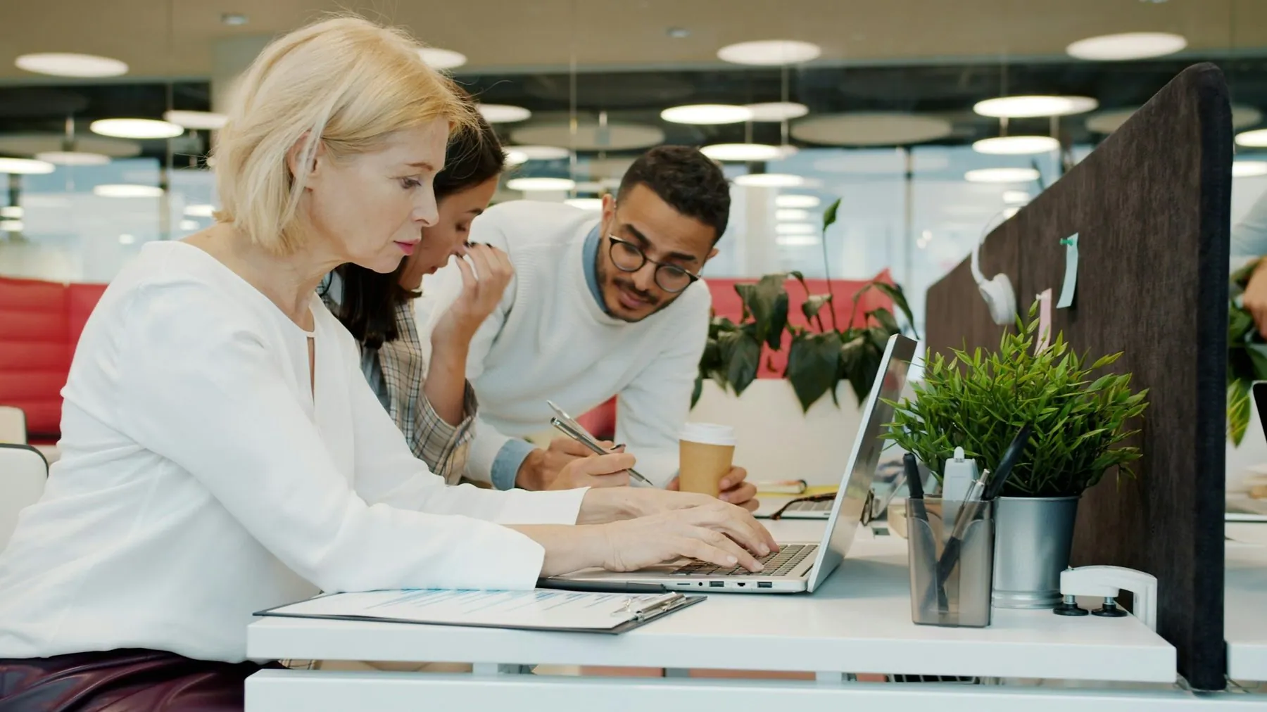 colleagues men and women using laptops and talking in shared workspace office. Modern technology, people and communicati