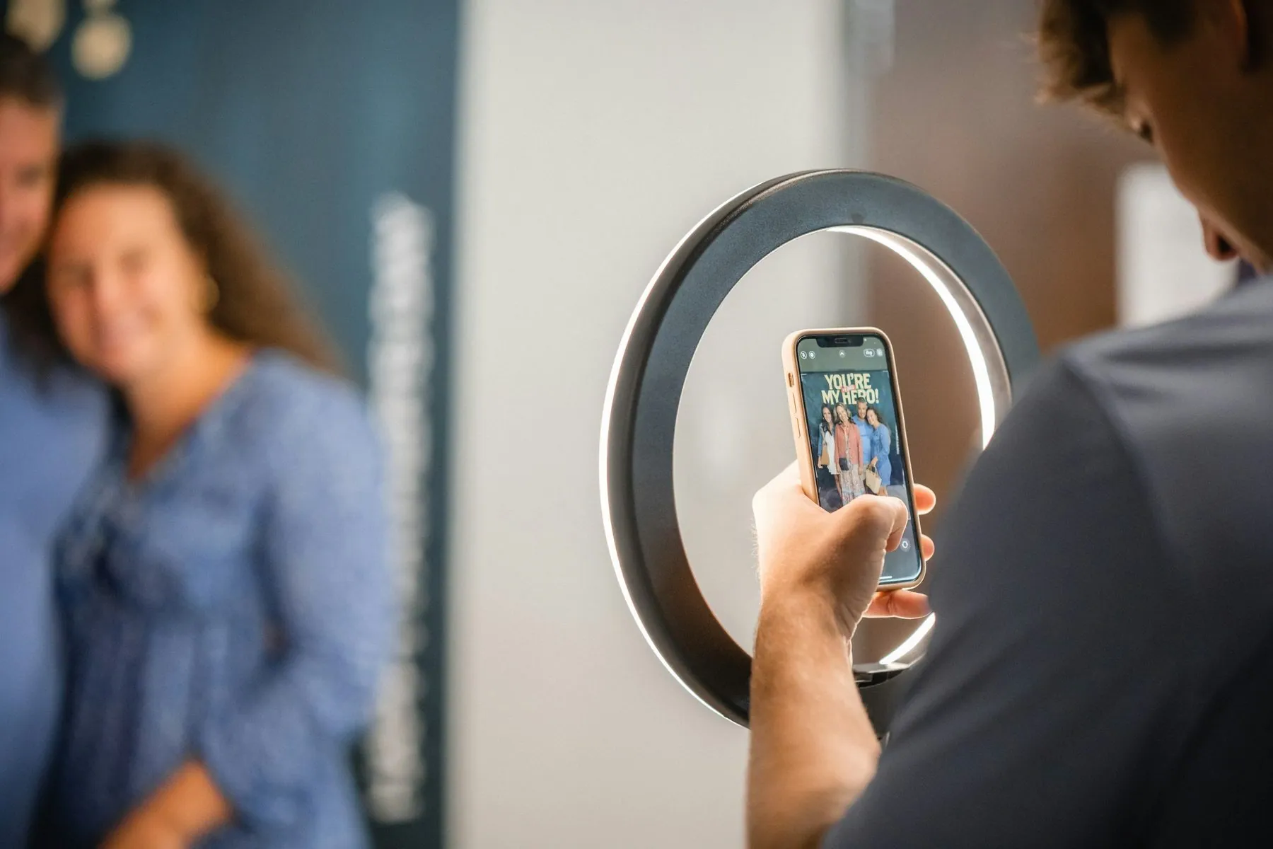 People taking a picture with a light ring. People posing for a picture.
