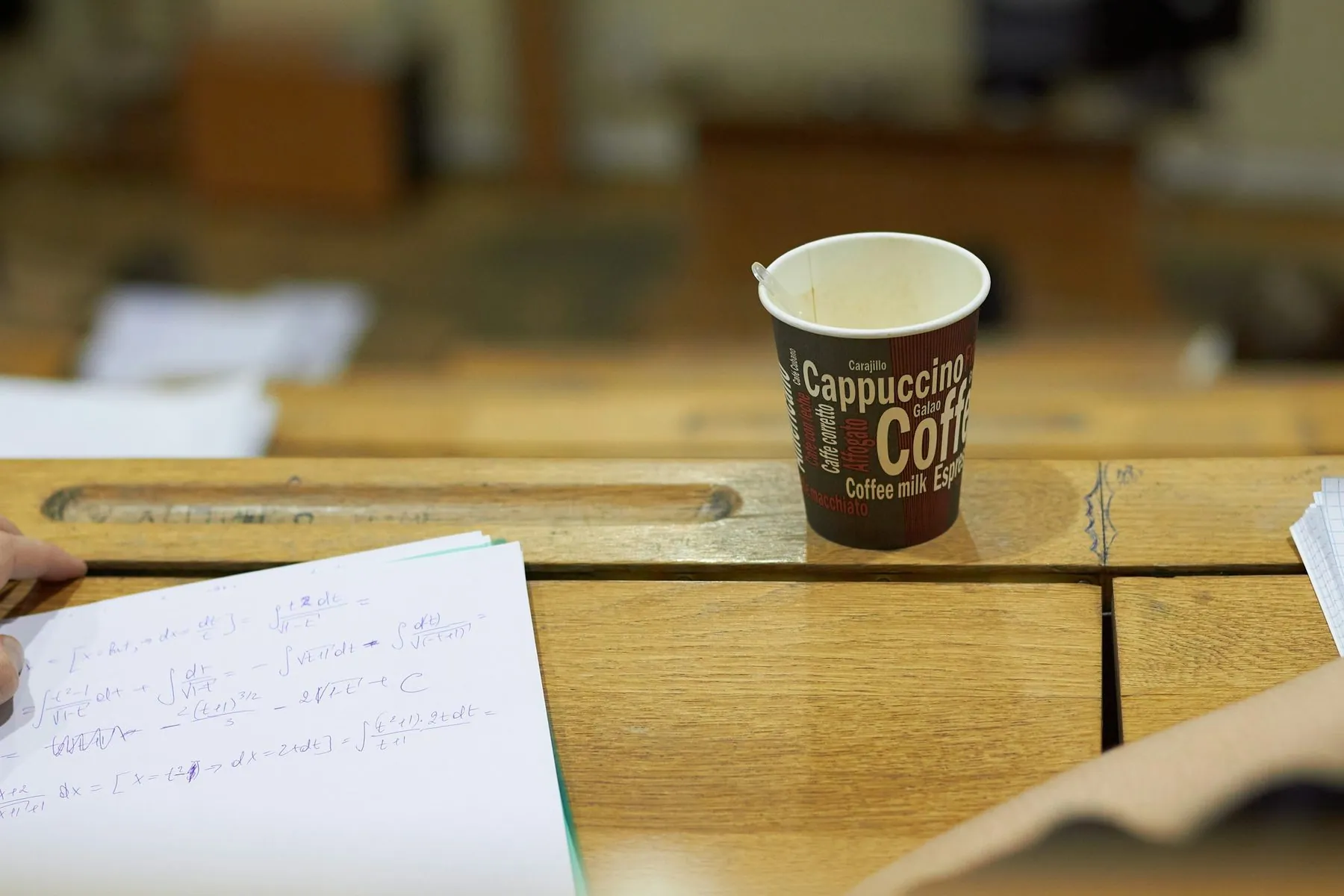 Coffee sits on a desk with papers