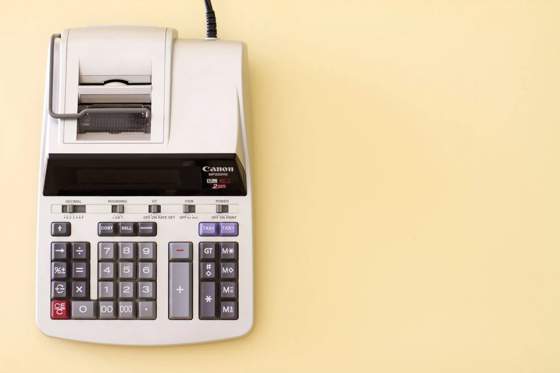 Ten key accounting calculator on yellow desk.