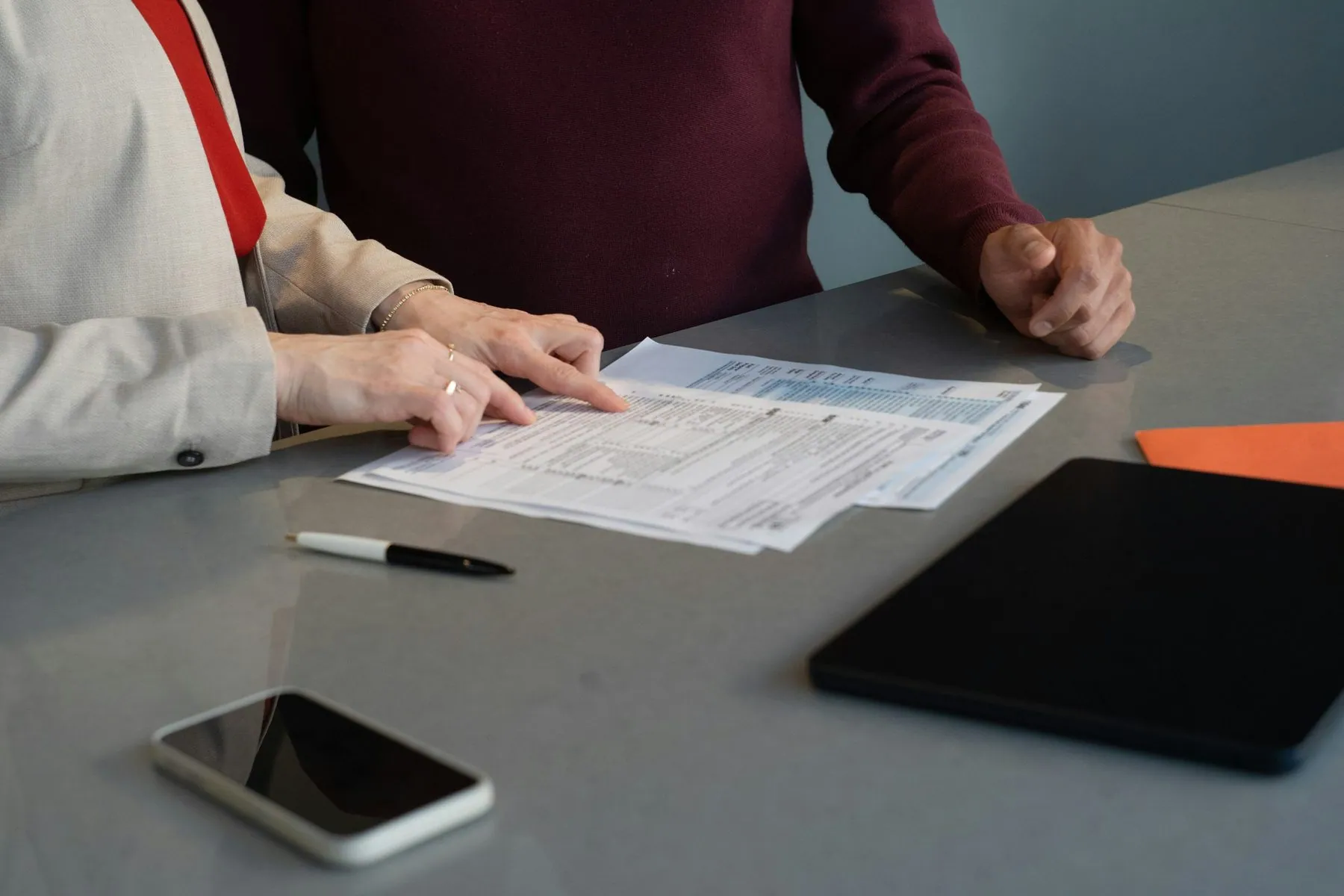 Two professionals reviewing paperwork at a conference table during a business meeting in San Francisco.