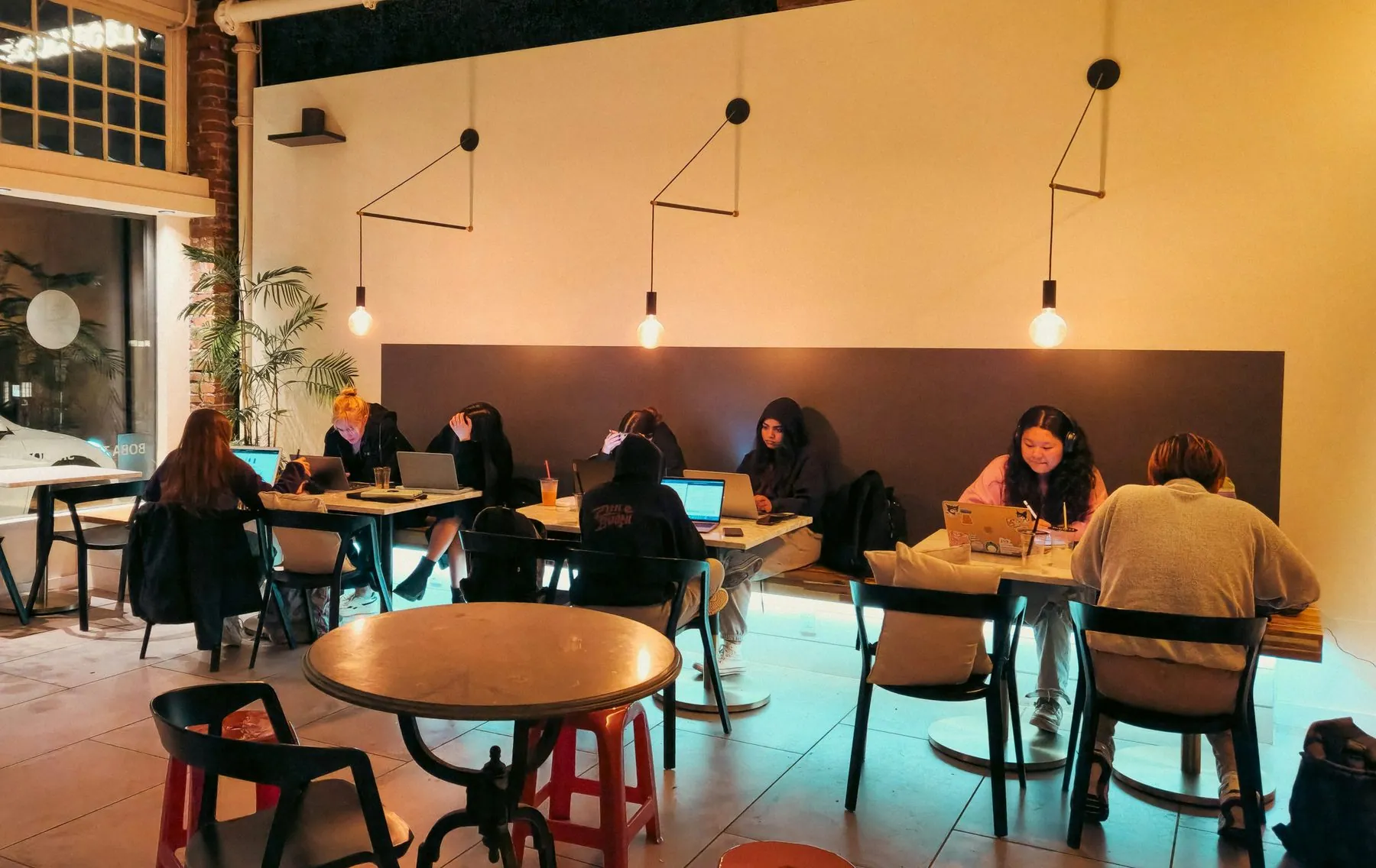 People are working on laptops in a cafe